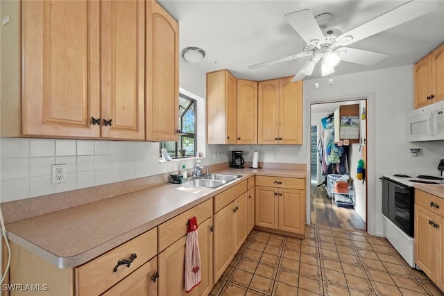 kitchen featuring white microwave, light brown cabinets, range with electric cooktop, and a sink