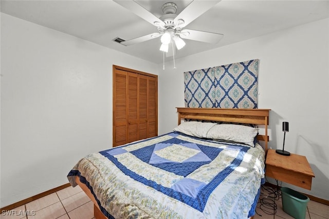 bedroom featuring light tile patterned floors, ceiling fan, a closet, and baseboards