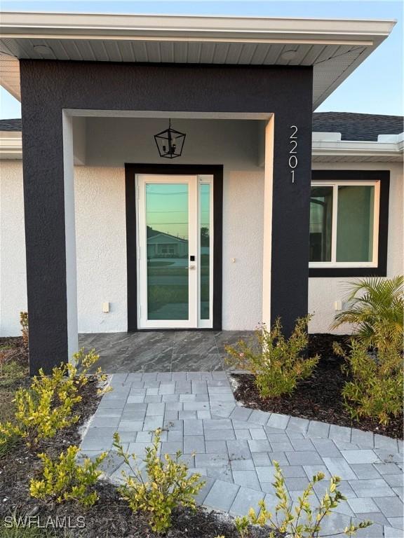 entrance to property featuring stucco siding