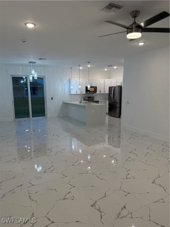 kitchen with decorative light fixtures, stainless steel appliances, visible vents, open floor plan, and white cabinetry