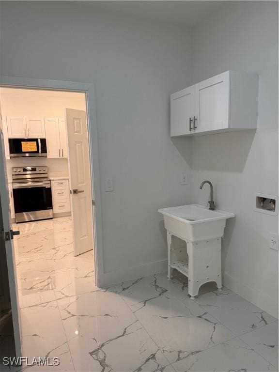 washroom with marble finish floor, laundry area, washer hookup, and baseboards