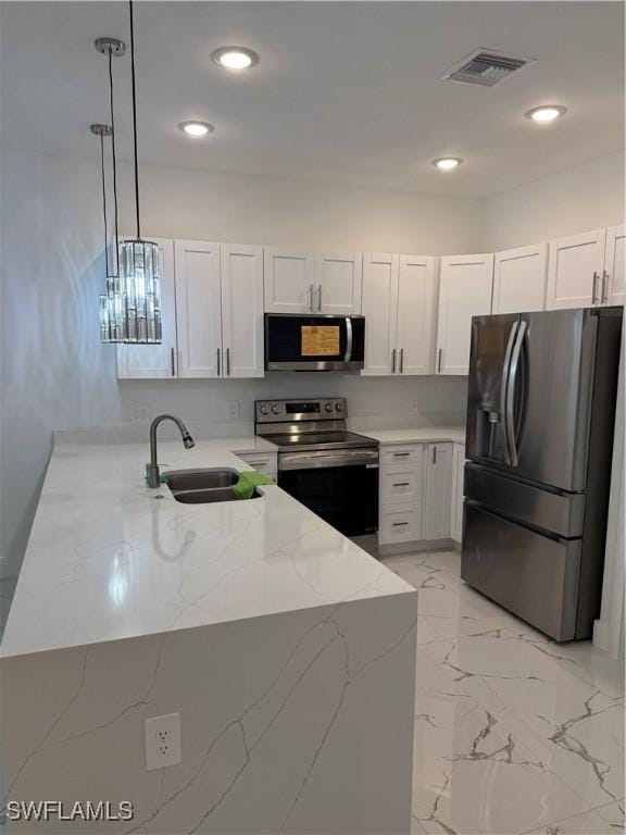 kitchen with visible vents, hanging light fixtures, appliances with stainless steel finishes, white cabinets, and a sink