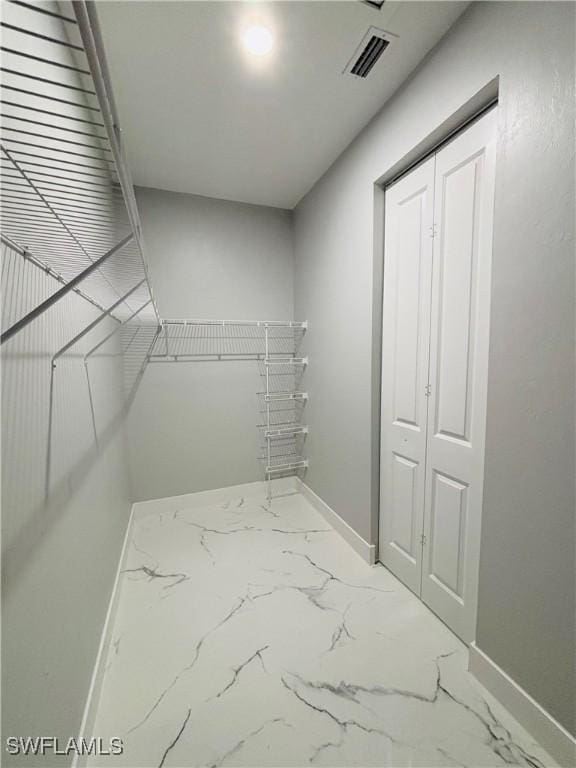 spacious closet with marble finish floor and visible vents