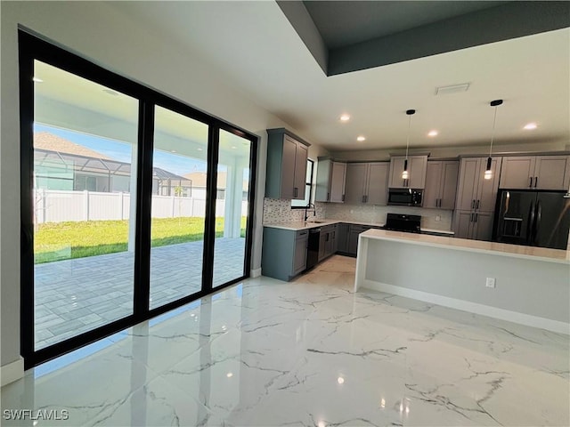 kitchen with marble finish floor, light countertops, gray cabinets, black appliances, and tasteful backsplash