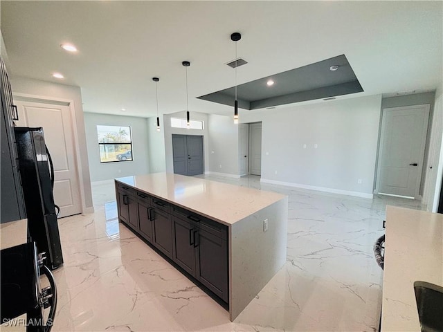 kitchen with visible vents, baseboards, marble finish floor, freestanding refrigerator, and a raised ceiling