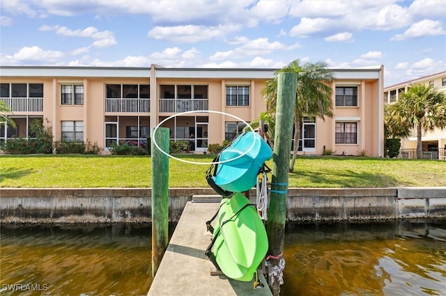 dock area with a yard and a water view