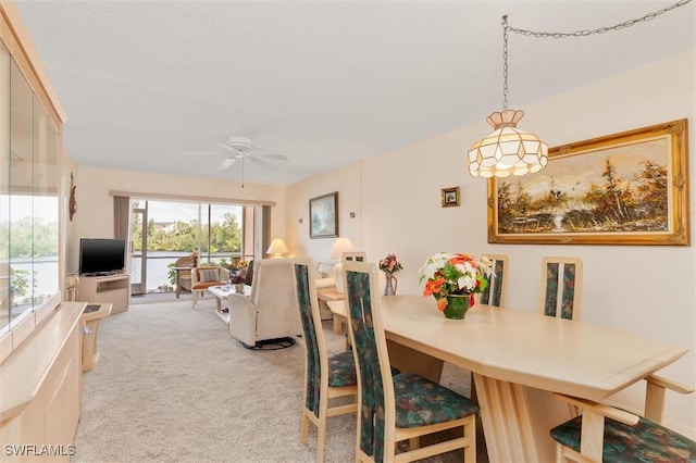 dining room featuring light carpet and ceiling fan