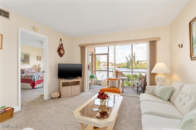 living room featuring light colored carpet, visible vents, and baseboards