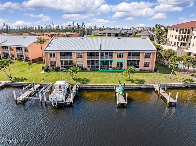 dock area featuring a lawn, a water view, boat lift, and a residential view