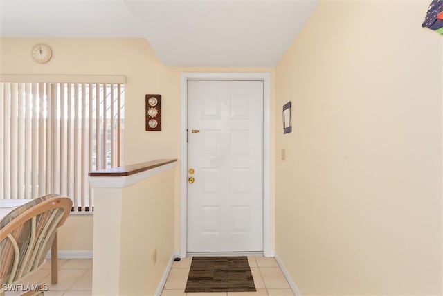 entryway with light tile patterned floors and baseboards