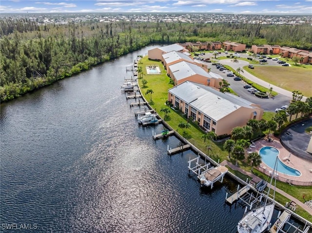 birds eye view of property with a water view and a view of trees