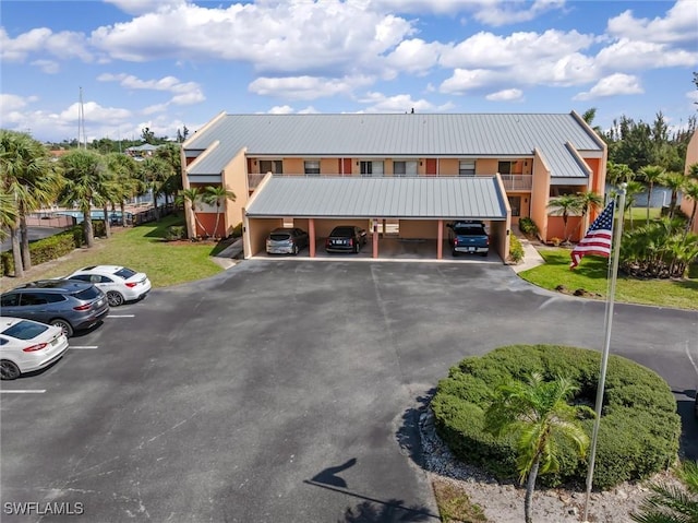 townhome / multi-family property featuring uncovered parking, metal roof, and a balcony