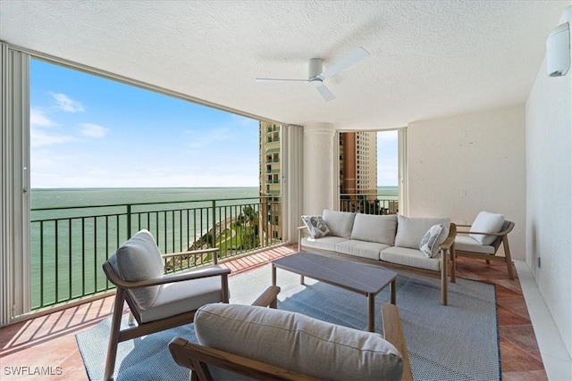 980 Cape Marco Dr Unit 805, Marco Island, FL 34145 - living room featuring a water view, a textured ceiling, ceiling fan, and ornate columns