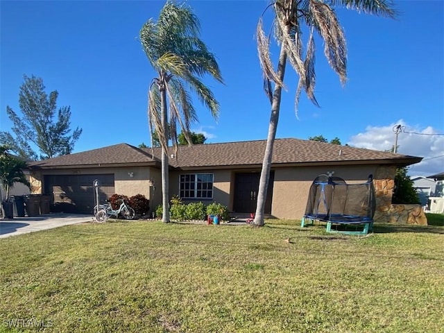 view of front of property with a garage, a trampoline, a front yard, and stucco siding