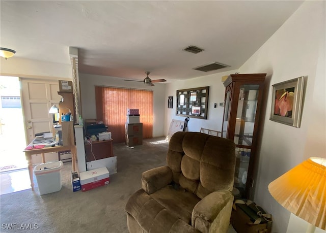 living area with a ceiling fan, a wealth of natural light, visible vents, and carpet flooring