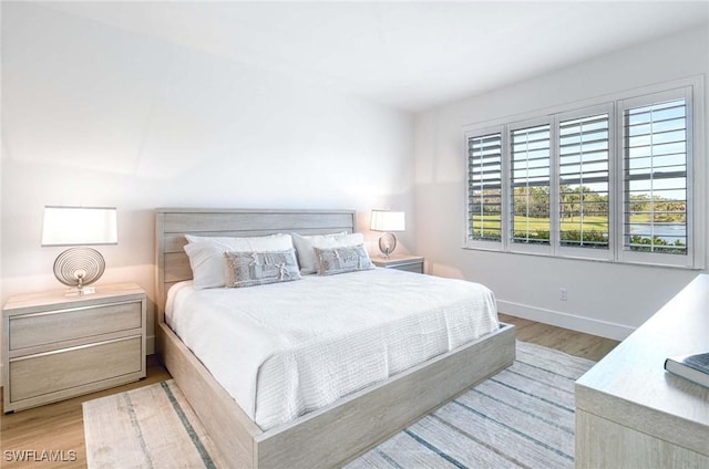 bedroom featuring light wood-style floors and baseboards