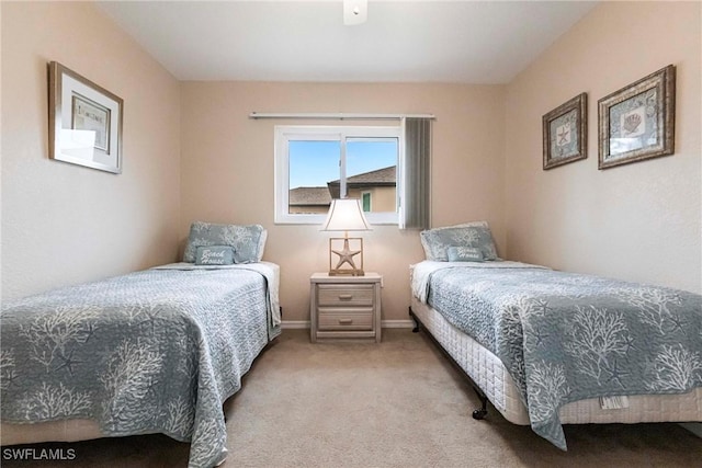 bedroom featuring baseboards and light colored carpet