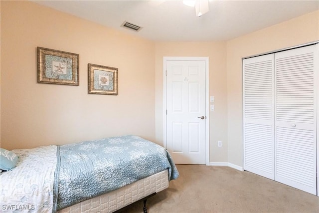 carpeted bedroom with a closet, visible vents, and baseboards