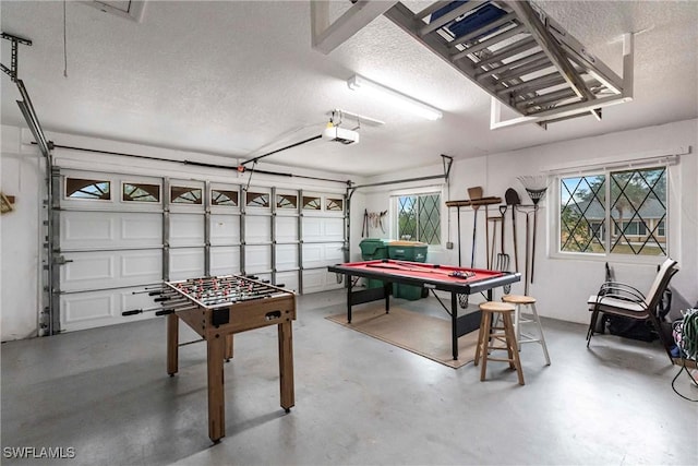 recreation room with a garage, plenty of natural light, finished concrete flooring, and a textured ceiling