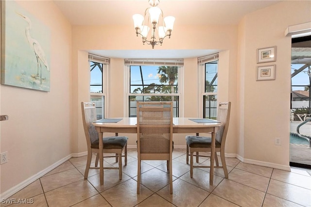 dining space featuring an inviting chandelier, light tile patterned floors, and baseboards