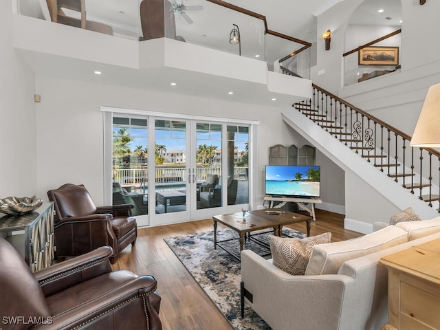 living area featuring dark wood finished floors, stairway, and a towering ceiling