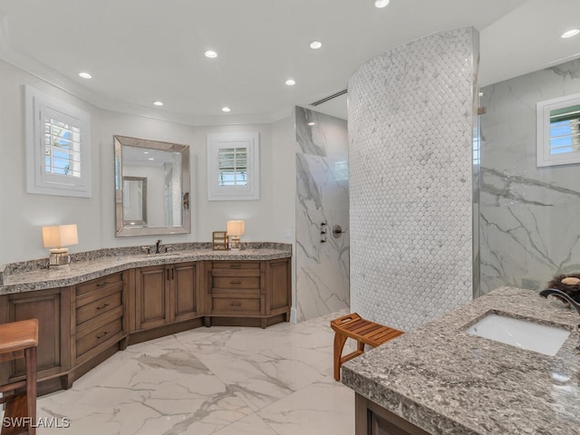 full bath with marble finish floor, a marble finish shower, two vanities, and a sink