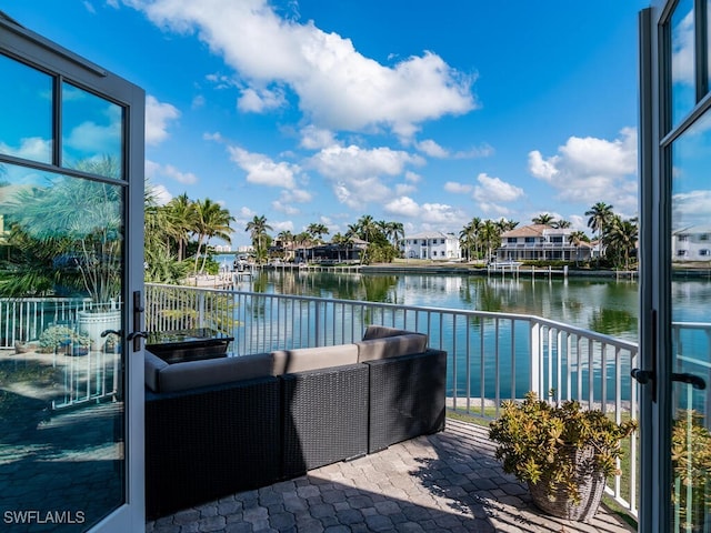 exterior space featuring a water view, a balcony, and an outdoor hangout area