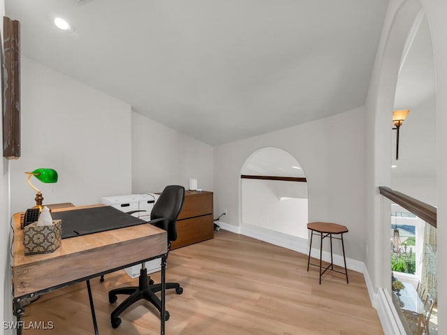 office space with arched walkways, light wood-style flooring, baseboards, and recessed lighting