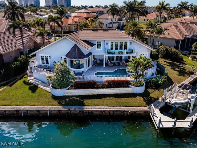 back of house featuring a patio area, a fenced backyard, a water view, and boat lift