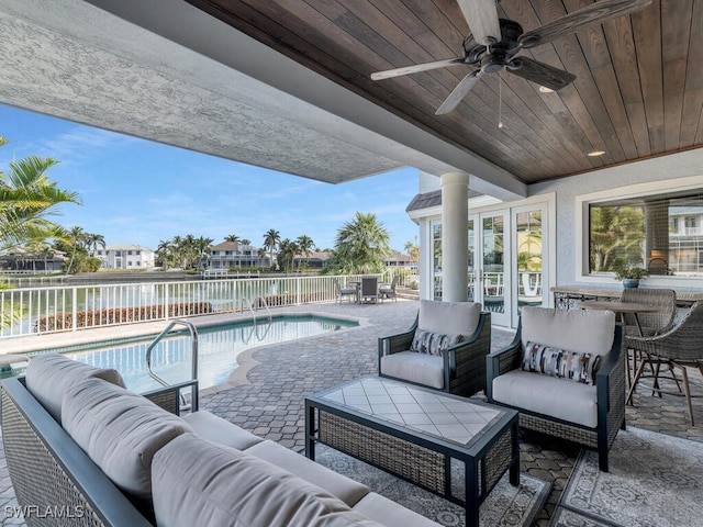 view of patio featuring a fenced in pool, ceiling fan, a water view, fence, and outdoor lounge area