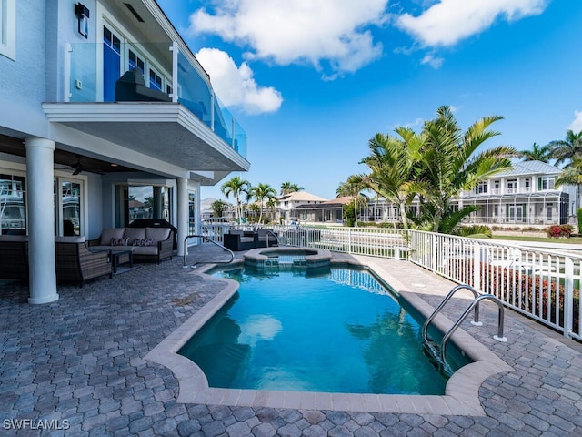 view of pool featuring a pool with connected hot tub, a patio area, outdoor lounge area, and fence