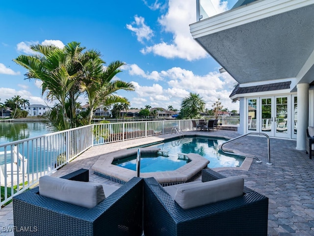 view of swimming pool with a pool with connected hot tub, a water view, a patio, and fence