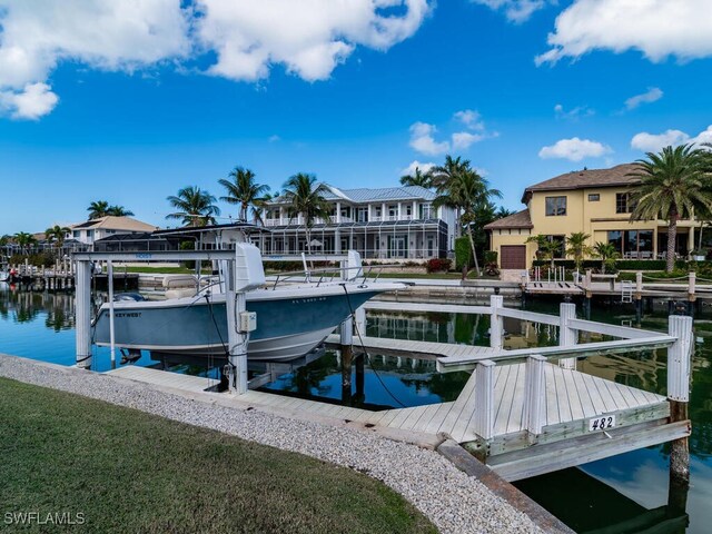 view of dock featuring a residential view, a water view, and boat lift