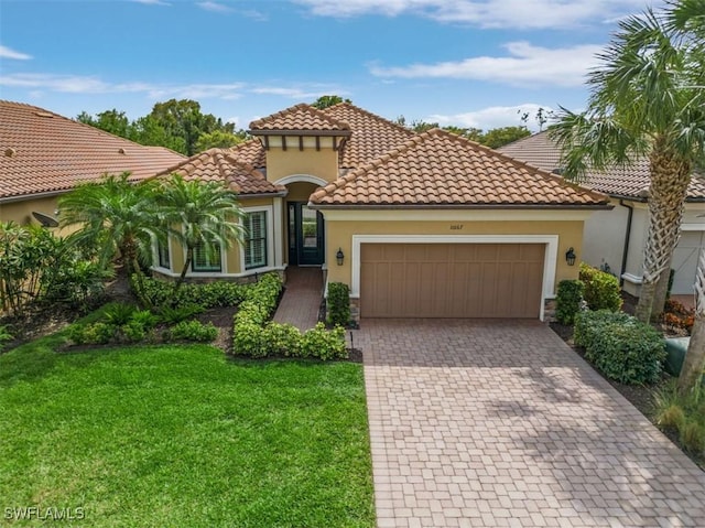 mediterranean / spanish-style home featuring a front lawn, decorative driveway, an attached garage, and stucco siding