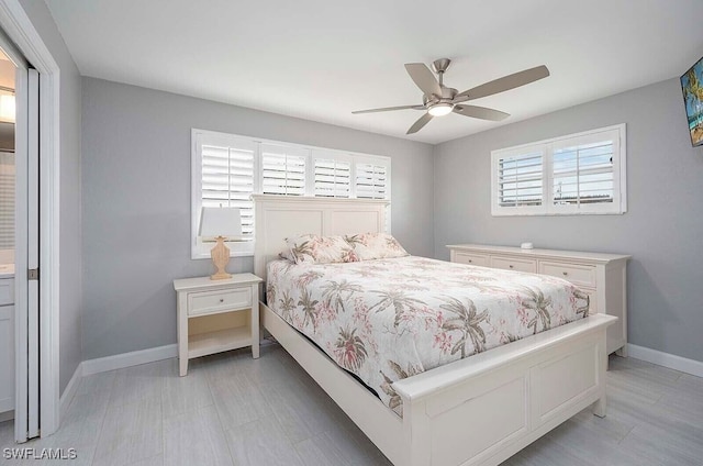 bedroom with multiple windows, a ceiling fan, and baseboards