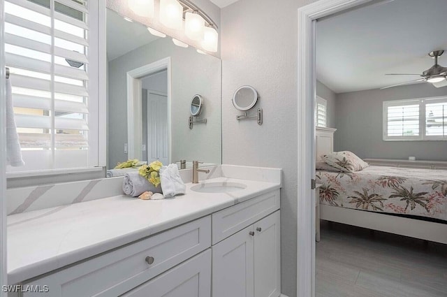 ensuite bathroom with connected bathroom, vanity, and ceiling fan