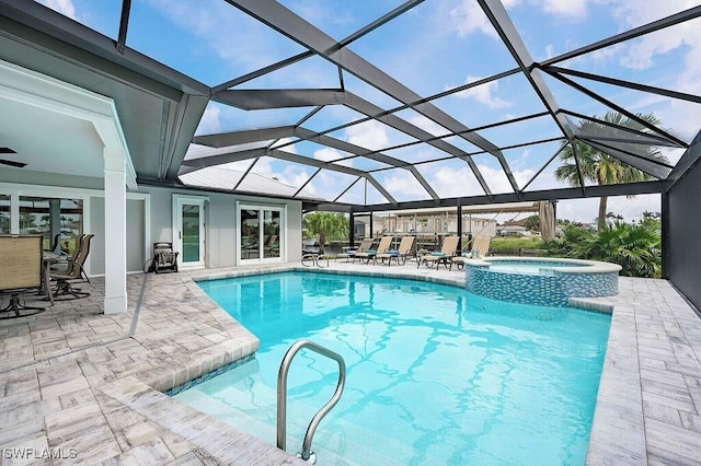 view of pool featuring glass enclosure, a pool with connected hot tub, and a patio area