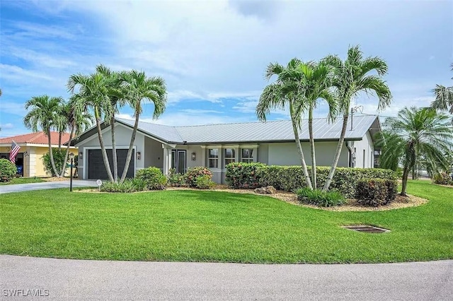 single story home featuring a garage, concrete driveway, a front lawn, and stucco siding