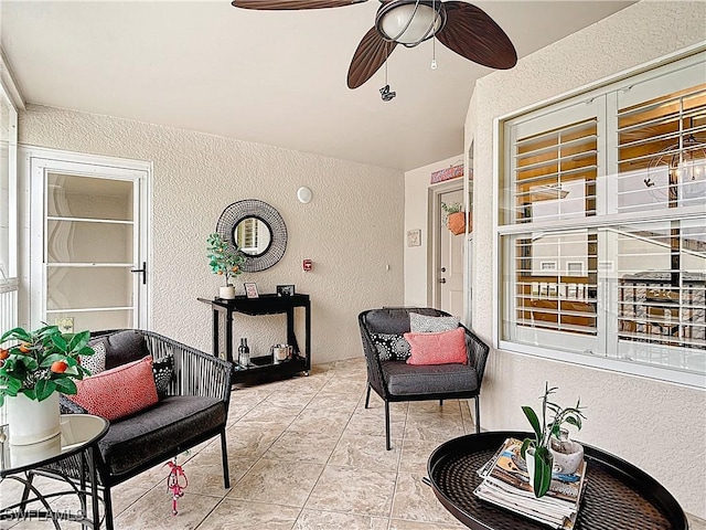 sunroom / solarium featuring a ceiling fan