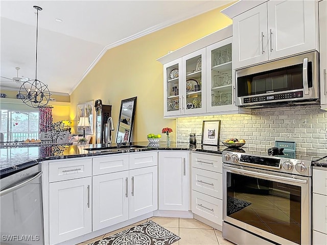 kitchen with light tile patterned floors, stainless steel appliances, lofted ceiling, ornamental molding, and a sink