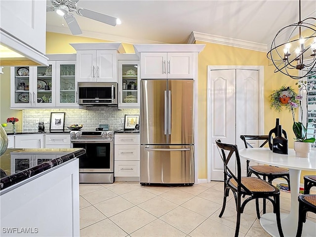 kitchen featuring tasteful backsplash, white cabinets, glass insert cabinets, stainless steel appliances, and crown molding