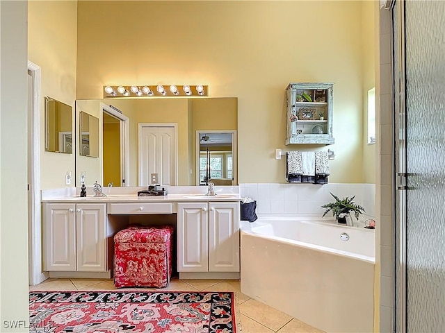 full bath featuring double vanity, a sink, tile patterned flooring, a high ceiling, and a bath