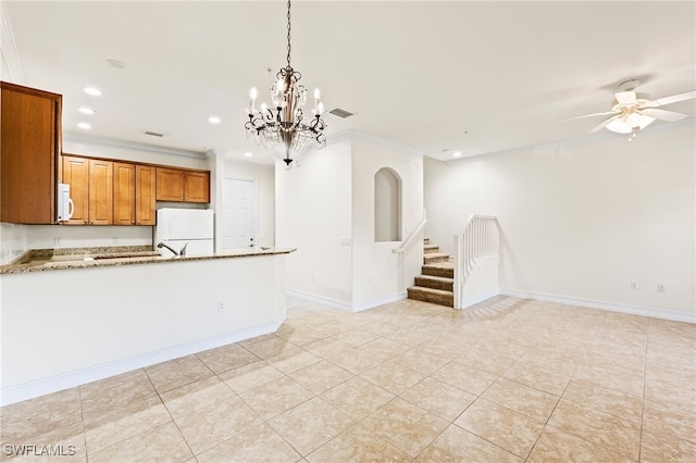 kitchen with white appliances, baseboards, visible vents, brown cabinets, and crown molding