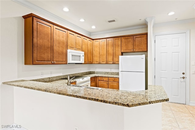 kitchen featuring a peninsula, white appliances, and light stone countertops