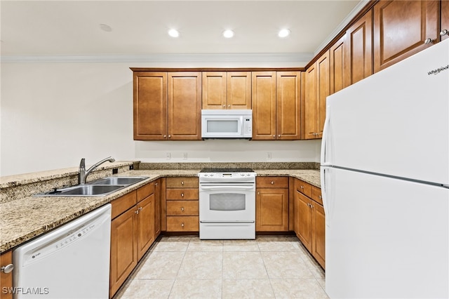 kitchen featuring white appliances, light tile patterned floors, brown cabinetry, ornamental molding, and a sink