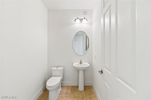 bathroom with toilet, tile patterned flooring, visible vents, and baseboards