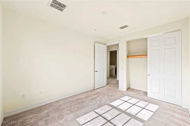 unfurnished bedroom with light colored carpet, a closet, visible vents, and baseboards