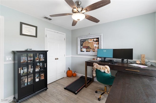 home office with visible vents, ceiling fan, light wood-style flooring, and baseboards