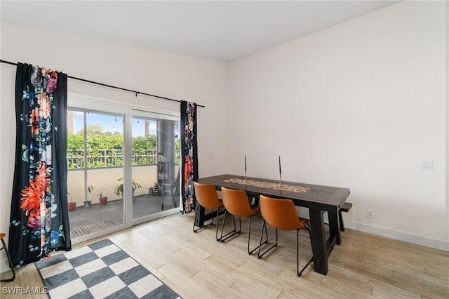 dining area featuring light wood-style floors and baseboards