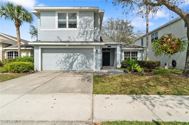 view of front facade featuring a garage, a front lawn, concrete driveway, and stucco siding